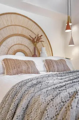 a bedroom with a large bed with a wooden headboard at Peni sol Superior Studios Lindos in Líndos