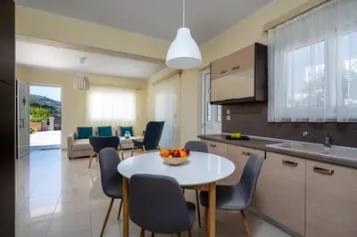 a kitchen and dining room with a table and chairs at Sunny Garden Apartments in Pastida