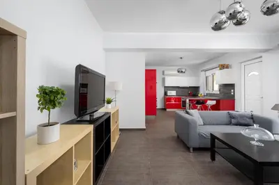 a living room with a couch and a tv at Sunny Garden Apartments in Pastida