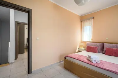a bedroom with a bed and a large mirror at Sunny Garden Apartments in Pastida