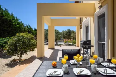 a table with plates of food on a patio at Sunny Garden Apartments in Pastida