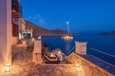a house with a balcony with a view of the water at Villa Leleka in Halki
