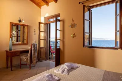a bedroom with a bed and a desk and a window at Villa Leleka in Halki