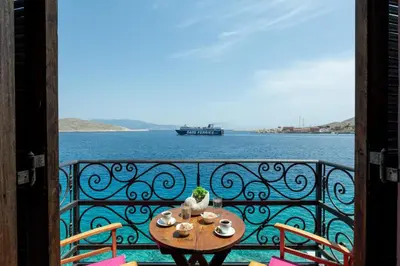 a table on a balcony with a view of the water at Villa Leleka in Halki