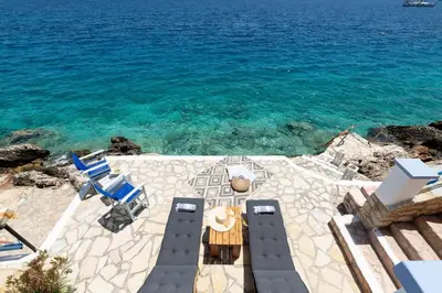 a patio with a table and chairs and the ocean at Villa Leleka in Halki