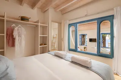 a bedroom with a large bed and a window at Cedrus Blue in Symi
