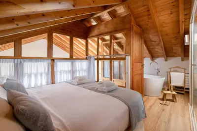 a bedroom with a large bed and a bath tub at Cedrus Blue in Symi