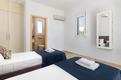 a white room with two beds and a mirror at Villa Melodia, 4 Bedroom Villa with Private Pool in Líndos