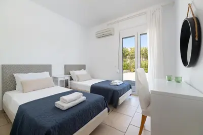a white room with two beds and a window at Villa Melodia, 4 Bedroom Villa with Private Pool in Líndos