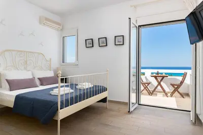 a bedroom with a bed and a balcony with the ocean at Villa Melodia, 4 Bedroom Villa with Private Pool in Líndos