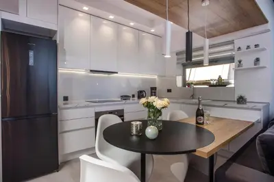 a kitchen with a black table and white cabinets at Rhodes Diamond luxury flat in the heart of town in Rhodes Town
