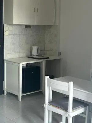 a kitchen with a white table and a white chair at Smart Accommodation Rhodes in Rhodes Town