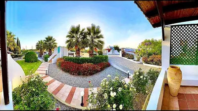 a garden with flowers and trees and a building at Tramonto Blue in Gennadi