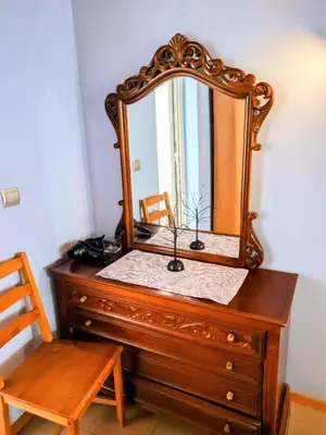 a mirror on top of a dresser with a chair at House with garden in city of Rhodes in Rhodes Town