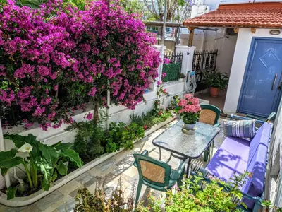 a patio with purple flowers and a table and chairs at House with garden in city of Rhodes in Rhodes Town
