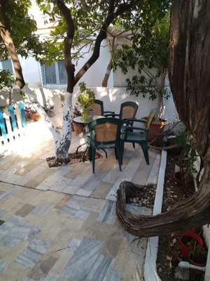 a patio with a table and chairs under a tree at House with garden in city of Rhodes in Rhodes Town
