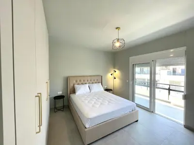 a bedroom with a bed and a sliding glass door at Serenity City Apartment in Rhodes Town