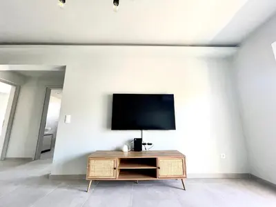 a living room with a tv on a white wall at Serenity City Apartment in Rhodes Town