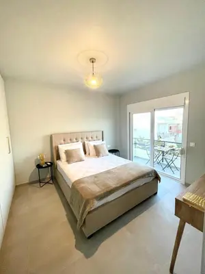 a bedroom with a large bed and a balcony at Serenity City Apartment in Rhodes Town