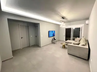 a living room with a couch and a flat screen tv at Serenity City Apartment in Rhodes Town
