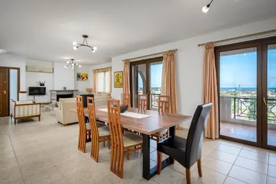 a dining room and living room with a table and chairs at 3 Roses Residence in Afantou