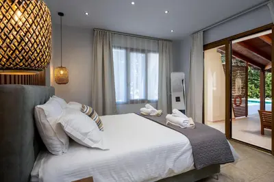 a bedroom with a large white bed and a patio at 3 Roses Residence in Afantou