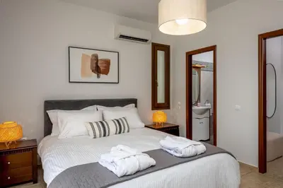 a bedroom with a bed with two towels on it at 3 Roses Residence in Afantou