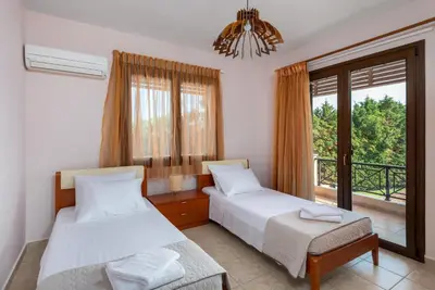 a bedroom with two beds and a balcony at 3 Roses Residence in Afantou