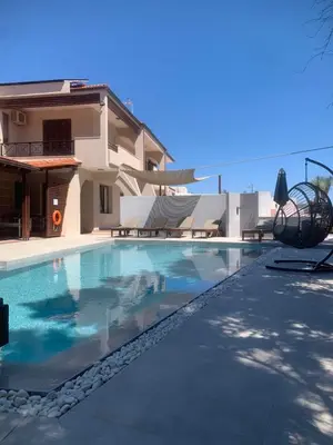 a swimming pool in front of a house at 3 Roses Residence in Afantou