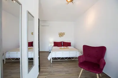 a bedroom with a bed and a chair and a mirror at My Home in RHO in Koskinou