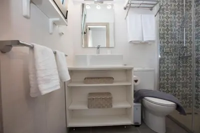 a bathroom with a sink and a toilet and a mirror at My Home in RHO in Koskinou