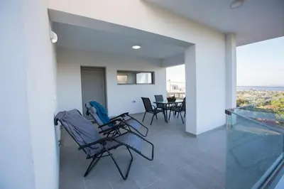 a balcony with chairs and a dining room with a view at My Home in RHO in Koskinou