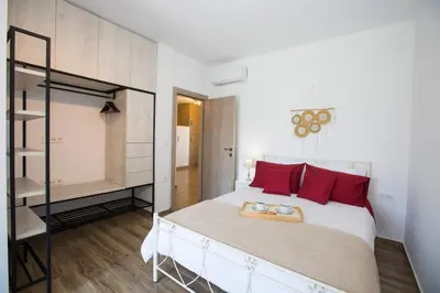 a bedroom with a large bed with red pillows at My Home in RHO in Koskinou