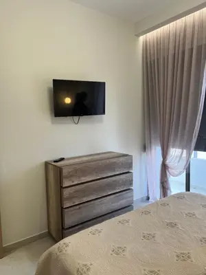 a bedroom with a dresser with a television on the wall at Psaropoula's Hidden Gem in Rhodes Town