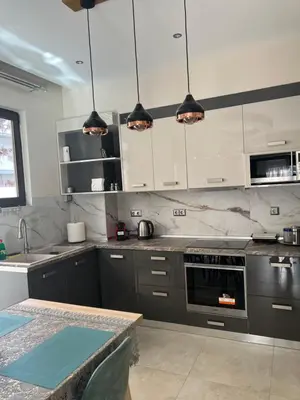 a kitchen with gray and white cabinets and a table at Psaropoula's Hidden Gem in Rhodes Town
