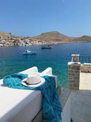 a hat sitting on a bed next to the water at Halki Sea Breeze - a waterfront villa in Halki