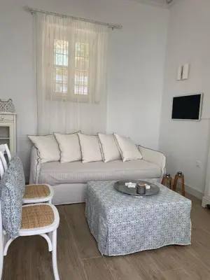 a living room with a couch and a table at Halki Sea Breeze - a waterfront villa in Halki