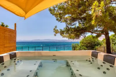 a swimming pool with an umbrella and a view of the ocean at Kavos beach house in Pefki Rhodes
