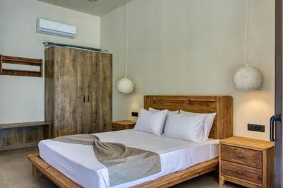 a bedroom with a bed with white sheets and pillows at Kavos beach house in Pefki Rhodes