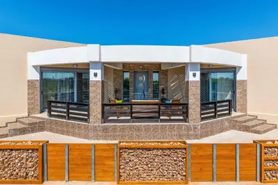 a house with a wooden fence in front of it at Villa Ifigeneia in Afantou