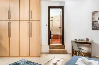a bedroom with wooden cabinets and a desk and a mirror at Villa Ifigeneia in Afantou