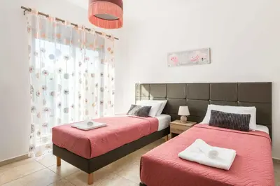 a bedroom with two beds and a window at Villa Ifigeneia in Afantou
