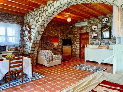 a living room with a stone wall at Rhodes traditional Cottage with private garden in Archangelos