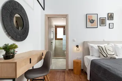 a bedroom with a bed and a desk and a mirror at Hamilton Grand Villa in Koskinou