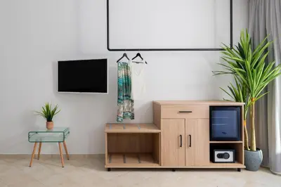 a living room with a tv and a wooden cabinet at Hamilton Grand Villa in Koskinou