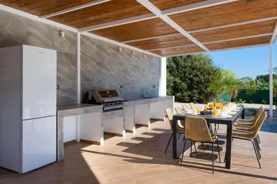 a kitchen and dining area with a table and chairs at Hamilton Grand Villa in Koskinou