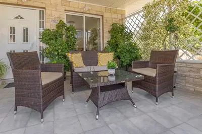 a patio with wicker chairs and a glass table at Casa di Gianna in Rhodes Town