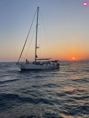a sail boat in the ocean at sunset at AGROLUX OASIS - A Private Pool Escape in Lush Agricultural Serenity in Sálakos