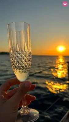 a person holding a wine glass with the sunset in the background at AGROLUX OASIS - A Private Pool Escape in Lush Agricultural Serenity in Sálakos