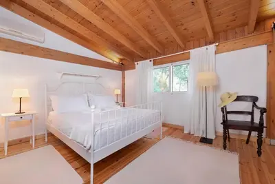 a bedroom with a white bed and a wooden ceiling at AGROLUX OASIS - A Private Pool Escape in Lush Agricultural Serenity in Sálakos